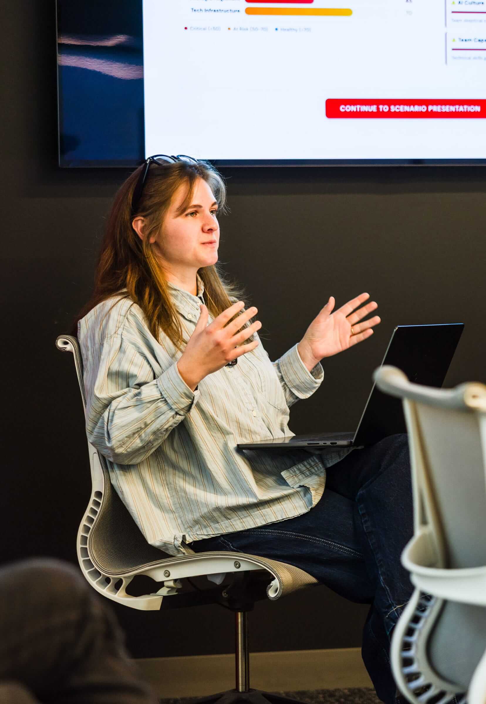 A very smart looking woman sitting in an office chair explaining something important.