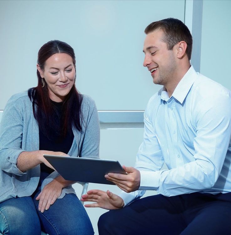 Man and woman on a tablet at work | DOT Cybersecurity Services