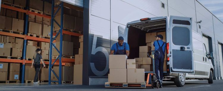 People working by a warehouse loading boxes into a van | Cybersecurity Best Practices for Supply Chain Risk Management