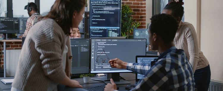 CISA Recommendations to Protect Against Cyber Threats | Man using his glasses to point to a computer screen in a modern work environment