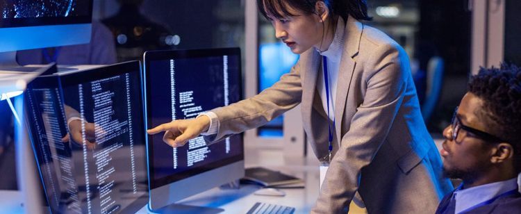 woman pointing at computer screen with code