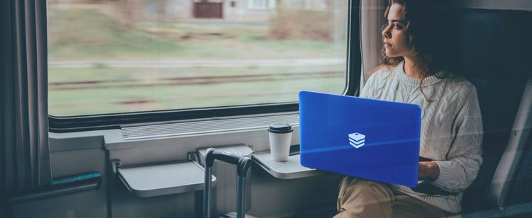 a college student on a train holding an edge device with the DOT logo on it