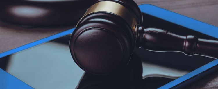 A judge's gavel resting on an tablet | cybersecurity compliance