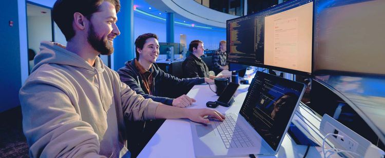 cybersecurity specialists working on a computer | how to stay updated on cybersecurity