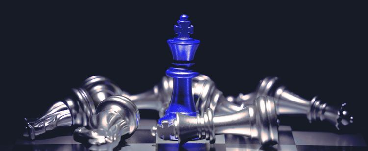 blue chess piece knocks down silver pieces on board | cyber kill chain: a guide to advanced targeted attacks