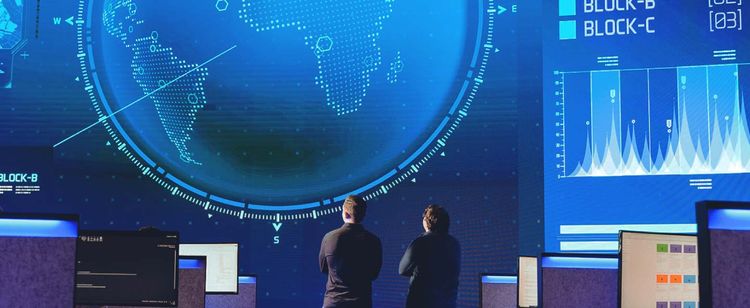 Two men looking up at a a pixelated image of the Earth on a giant screen