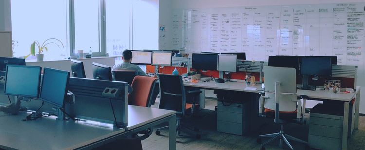 empty office with desks and computers and whiteboards | why the cybersecurity talent shortage is so bad right now