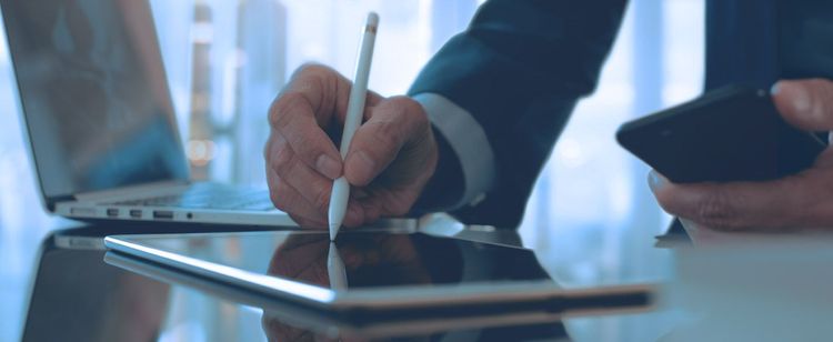 a man writing with a digital pen on an ipad | how to handle cyber liability insurance application questions