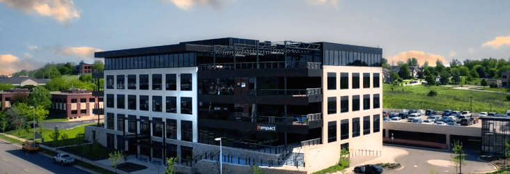 black and white office building with partly cloudy blue skies