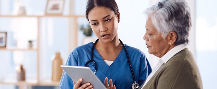 A nurse reading off a tablet to an older woman