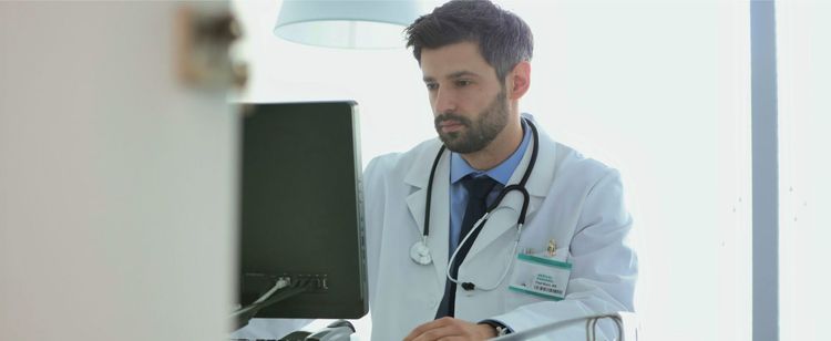 A health practitioner sitting behind a computer