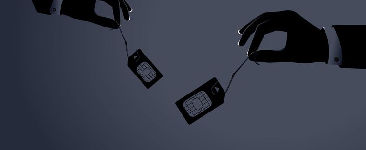 Two shadowy hands dangling SIM cards 