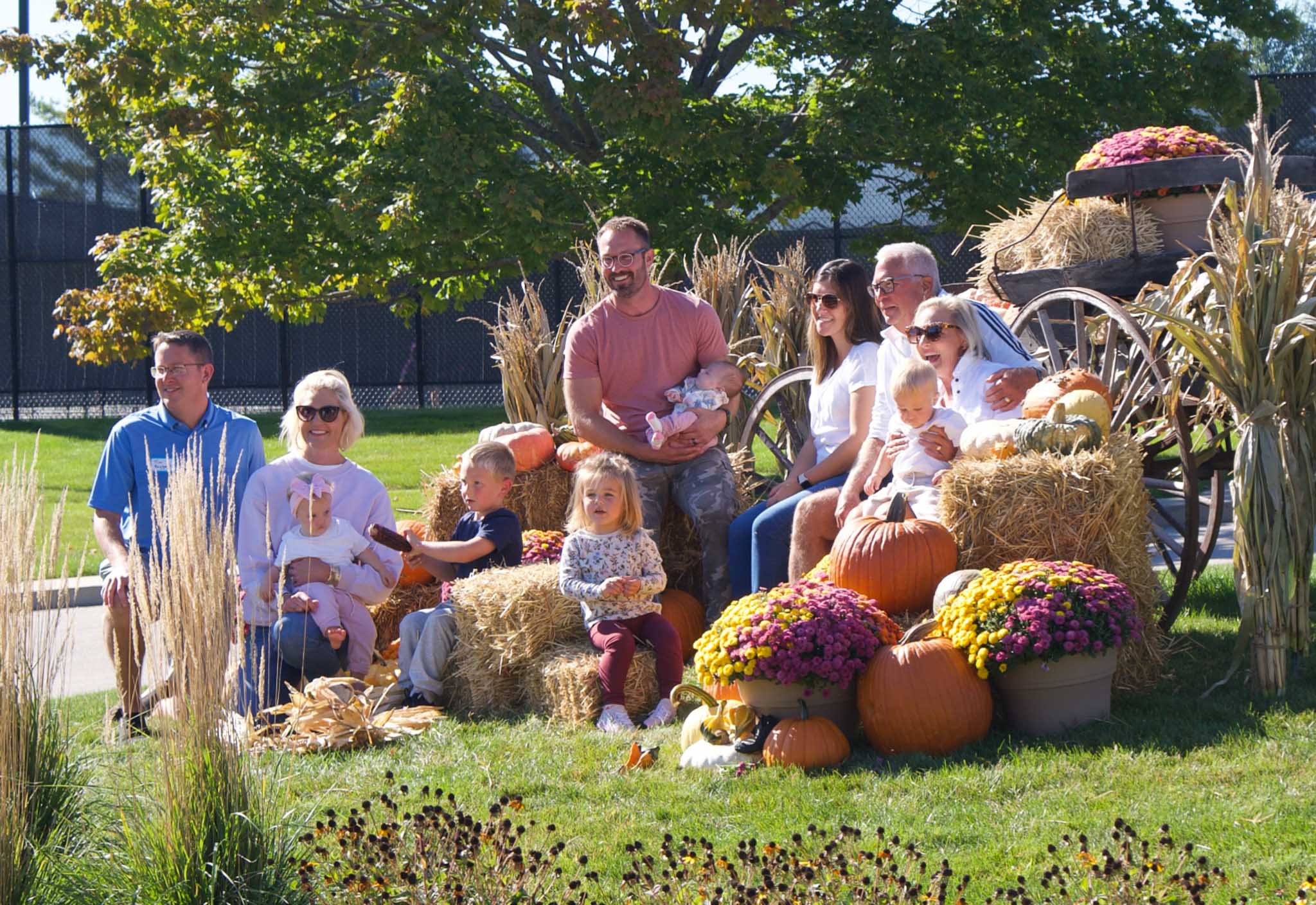A large family gathers around fall decorations in Geneva National Community