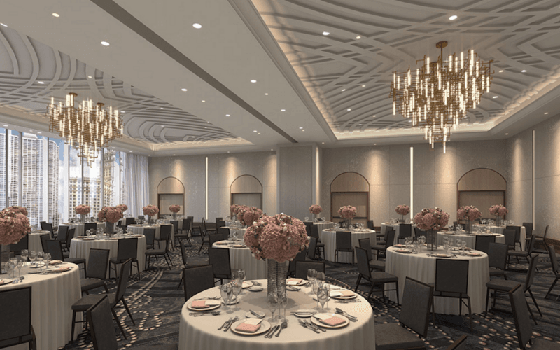 A dining hall inside London House with luxurious chandeliers, tables and decorations.