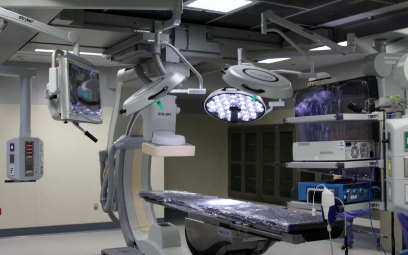 Operating room with medical and operating equipment and overhead lights required for surgery.