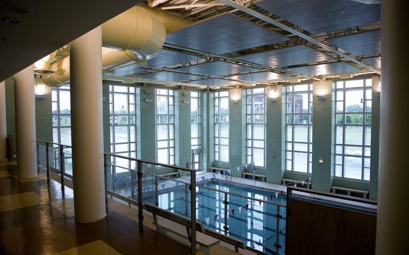The indoor pool illuminated by various wall lights during the evening.