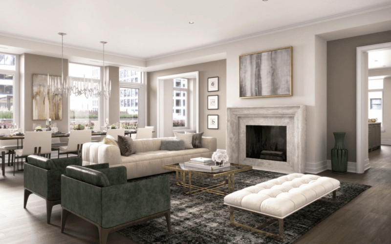 A residential room decorated with art pieces, chandeliers, a fireplace, couches and tables with gold accents.