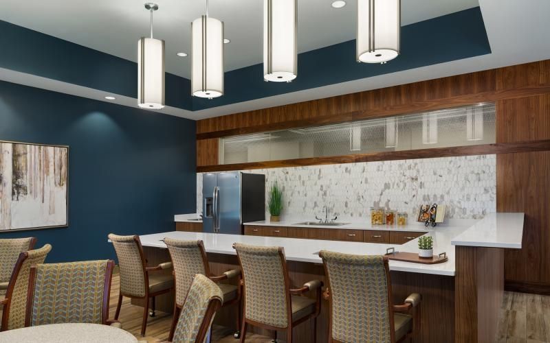 Another view of the bistro dining area with pendant lighting, a fridge and a large countertop area.