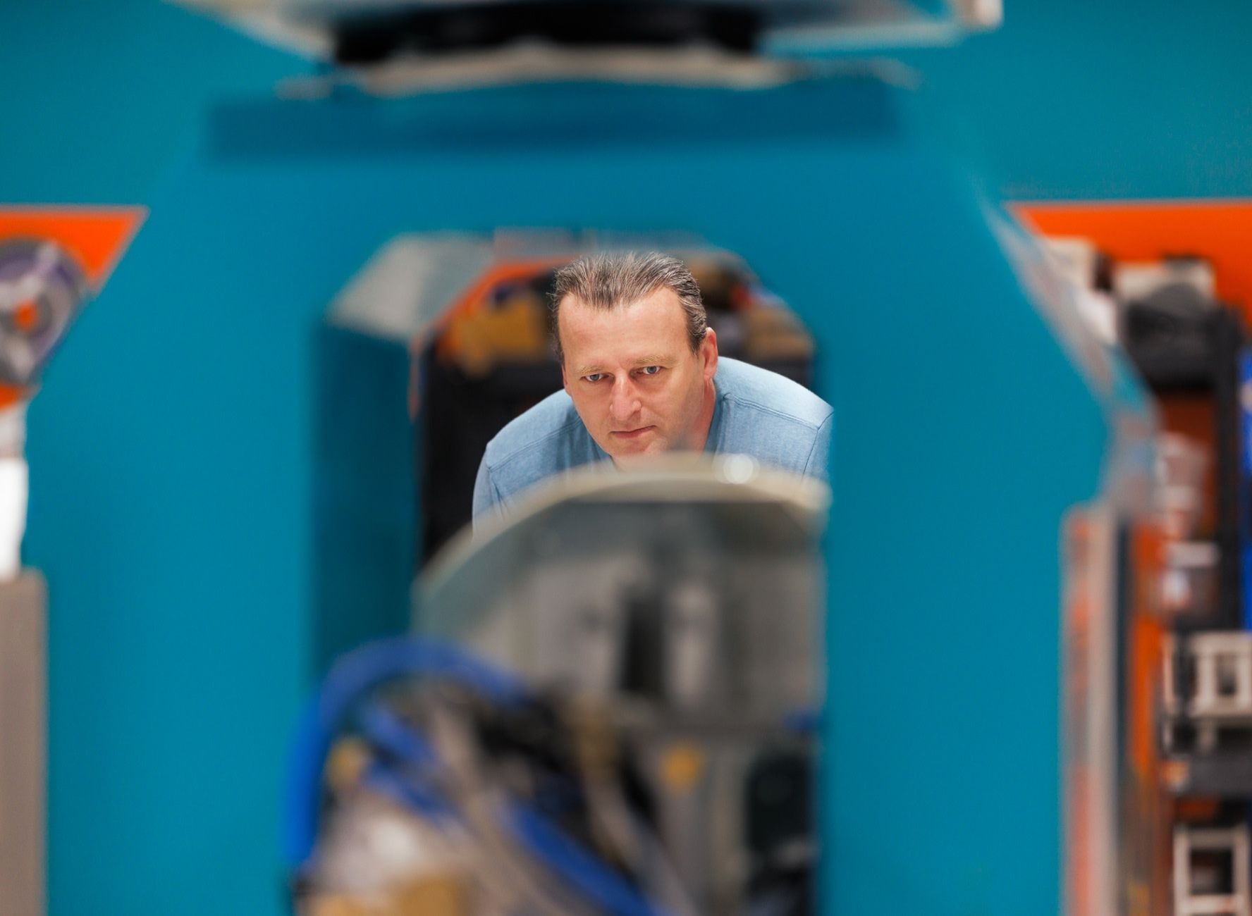 Atlantis fabrication shop worker watching Poseidon machinery cut through stone slabs
