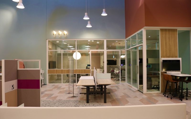Working space with a few desks and surrounded by meeting rooms.