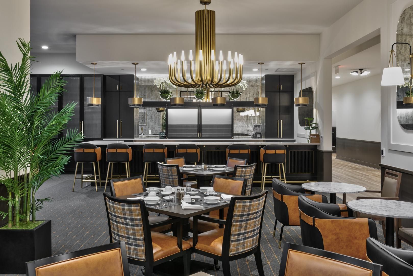 Lounge at American House Oak Park Senior Living with comfortable chairs and a large center-piece chandelier.