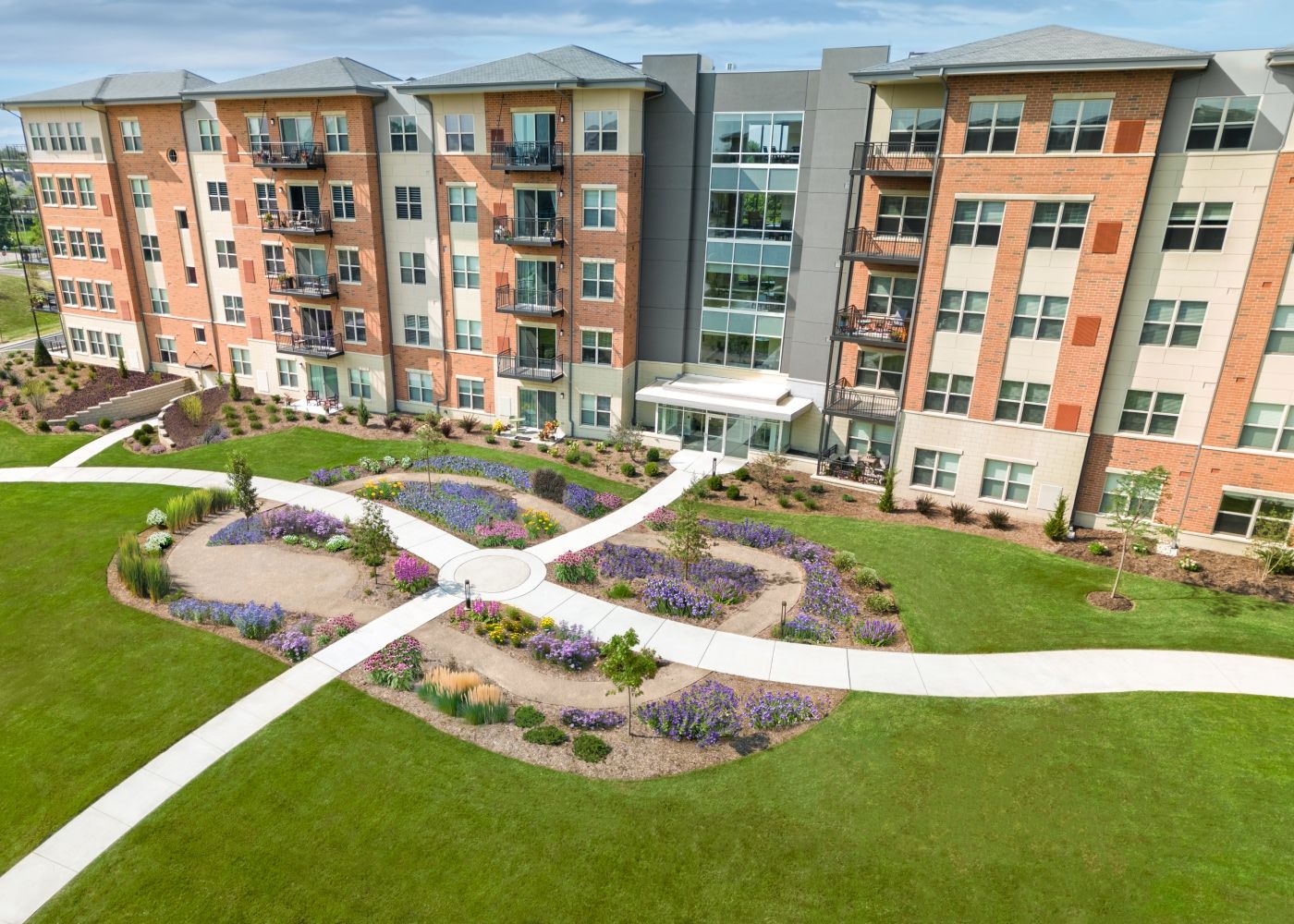 Exterior side of the property with the small garden filled with flowers in the middle.