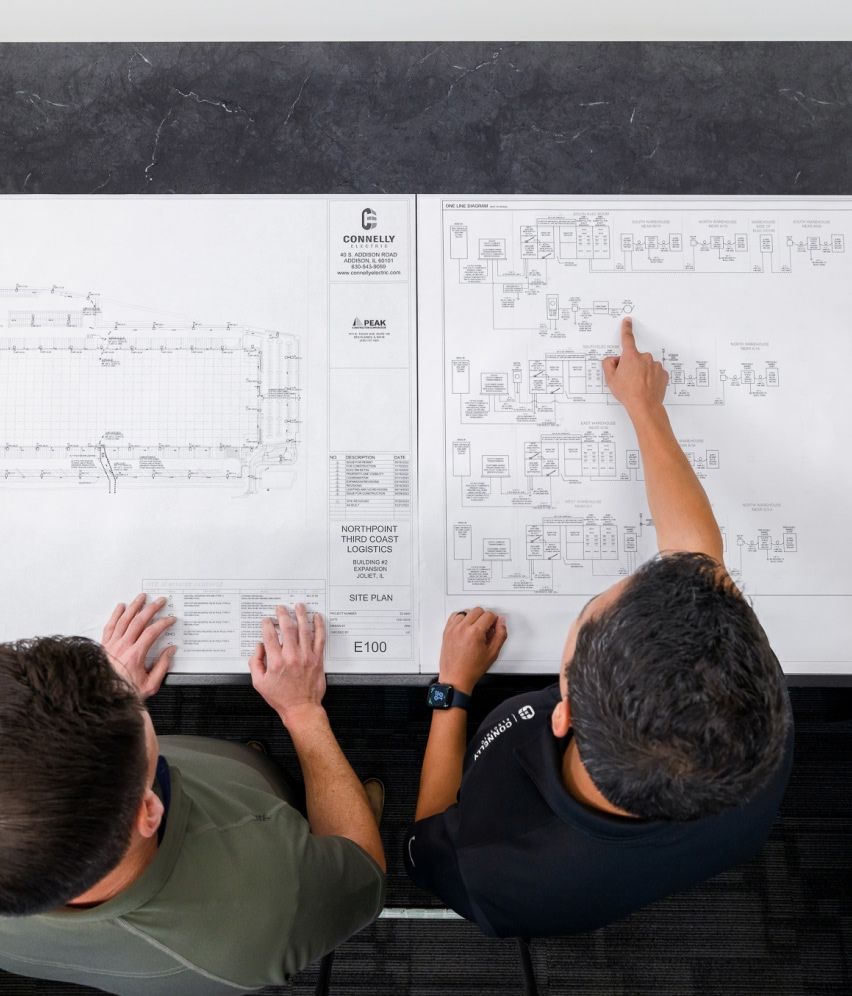Connelly Electric engineers reviewing blueprints of electrical systems
