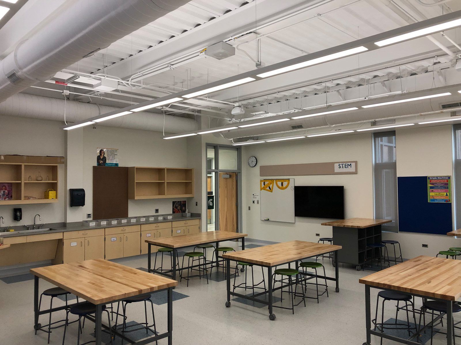One of East Prairie's classrooms, showing some tables, cabinets and a tv.
