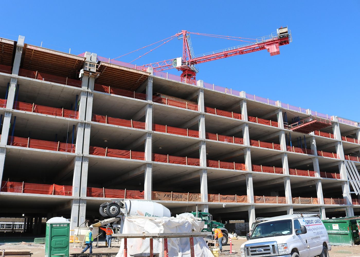 Crane showing behind the construction site of the parking site structure.
