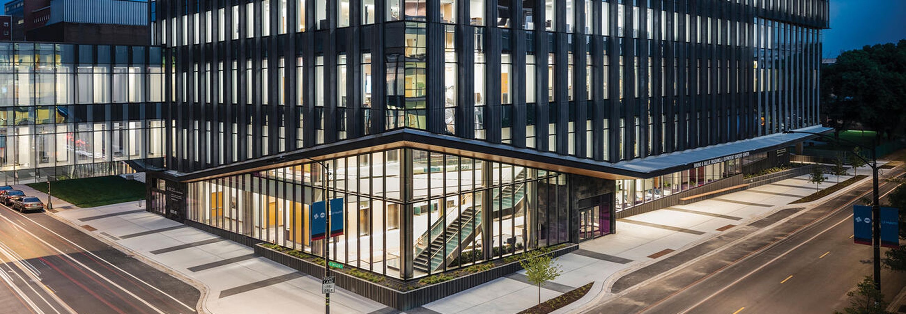 Outside view of the UI Health building at nighttime showing the entrance and windows illuminated.