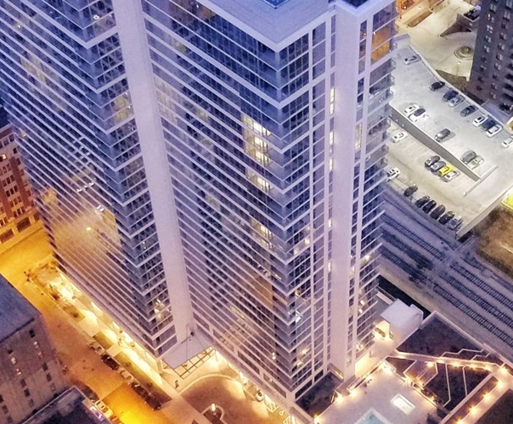 The exterior of Alta Roosevelt with bright lights at night.
