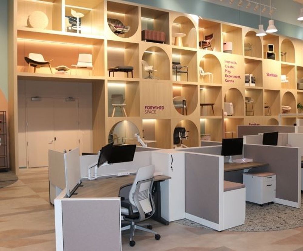 Co-working space at Forward Space with a tall wall unit that showcases brightly lit chairs inside it.