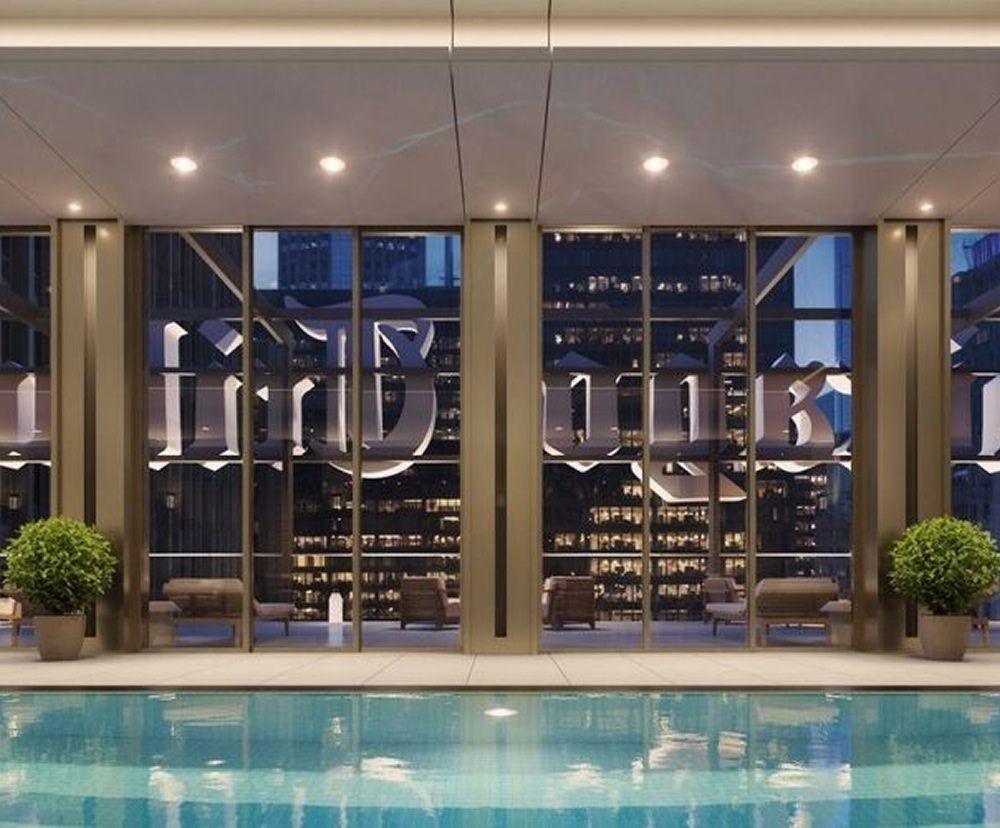 The swimming pool at the Tribune Tower with lighting illuminating it at night.
