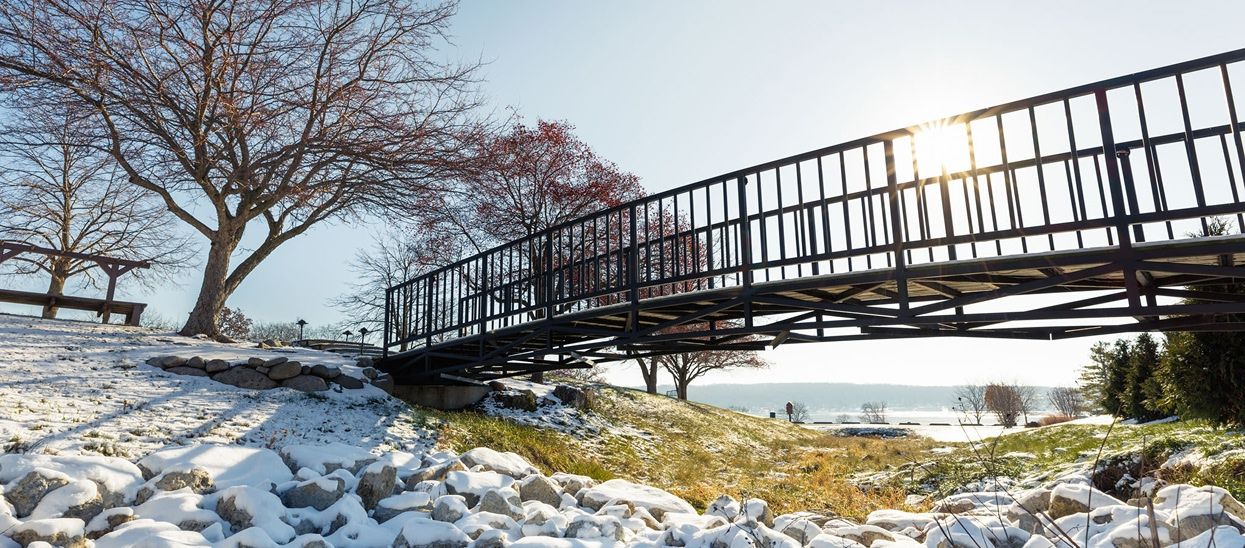 Snow-covered rocks surround a wooden bridge within Geneva National Community