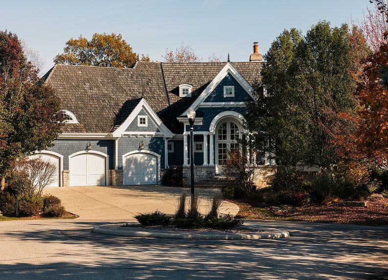 outside of a large traditional home with three car garage