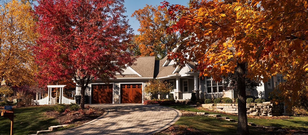 Front of a house with red and orange leaves on the trees