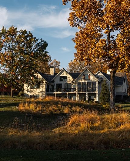 House overlooking field with orange leaves on trees during autumn