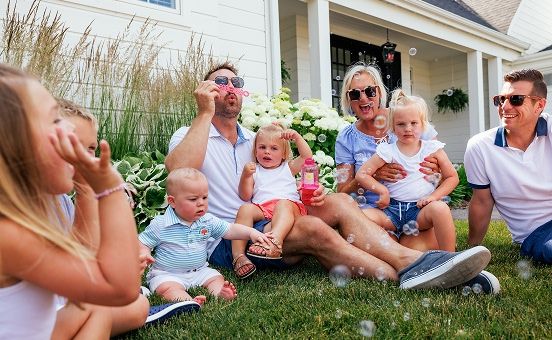 parents with their young children blowing bubbles outside