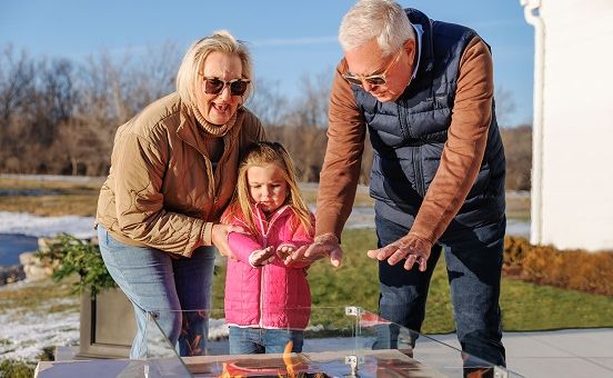 grandparents playing with granddaughter outside