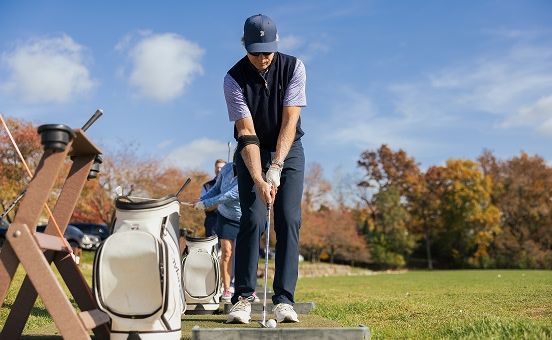 man teeing off at a driving range