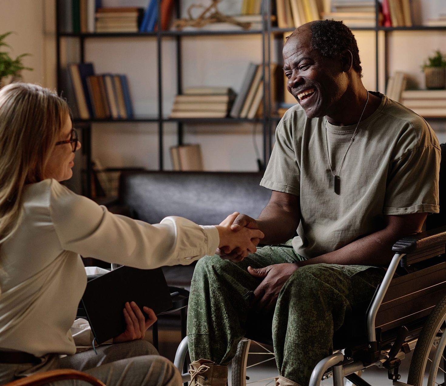 veteran in wheelchair shaking hands with a fellow vet