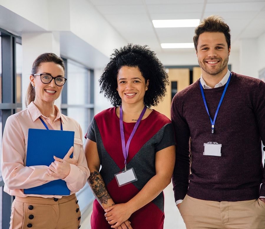 three teachers in a school hallway
