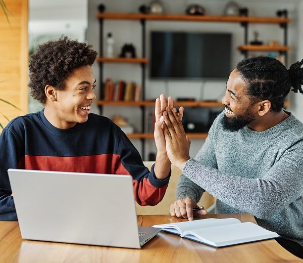 classmates high-fiving while working on homework