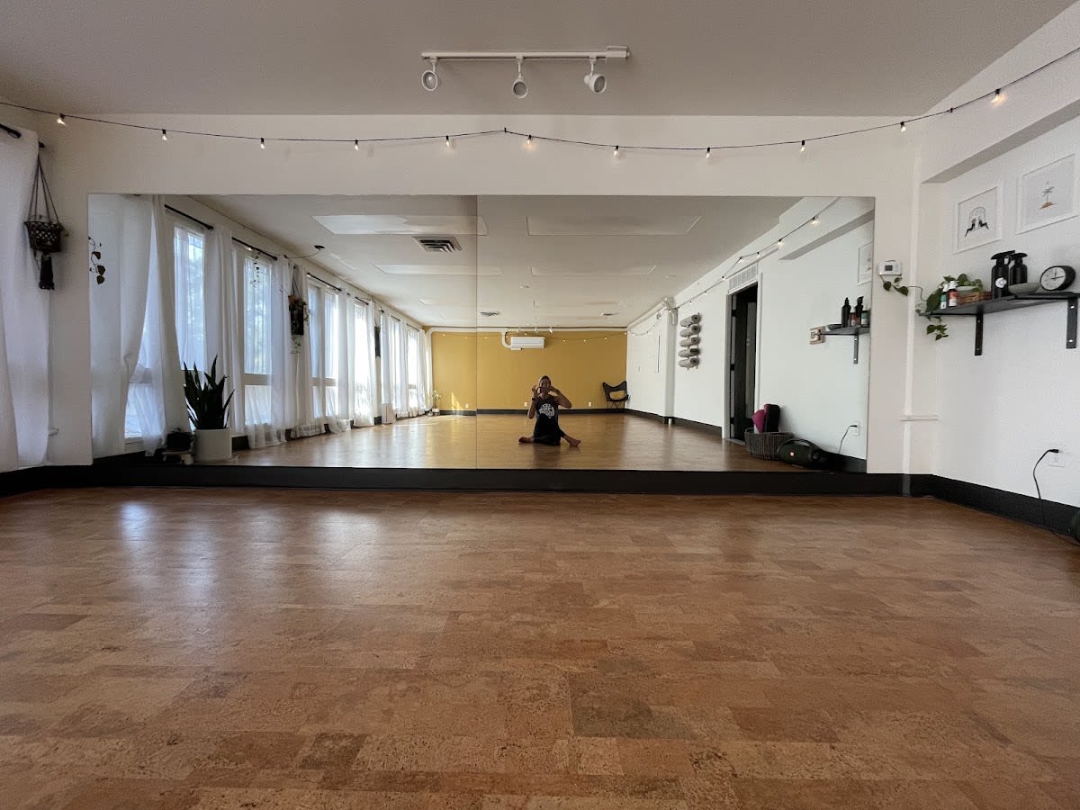 Yoga instructor seated in the mirrored Common People Yoga studio in Salem