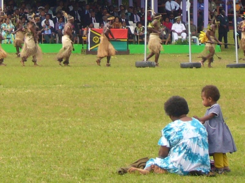 Woman and child watch men from the sidelines. Tracey/Flickr, originally from DevPolicy blog.