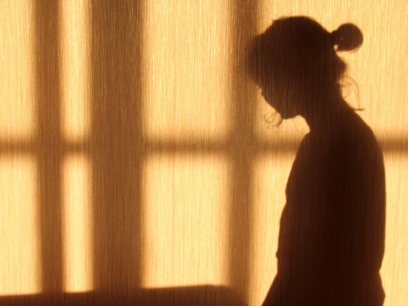 A woman's shadow against a narrow wall. Shutterstock.