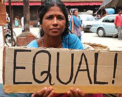 Nepali woman holding a sign saying "Equal!"