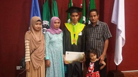 Syarif at his graduation, with his parents and younger sisters.