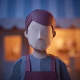 A paper-craft model figure of a café owner behind the counter.