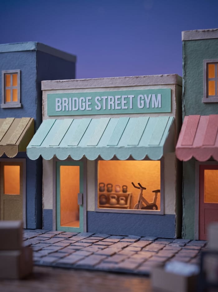 A model gym shopfront with a mint awning, kettlebells in the window.